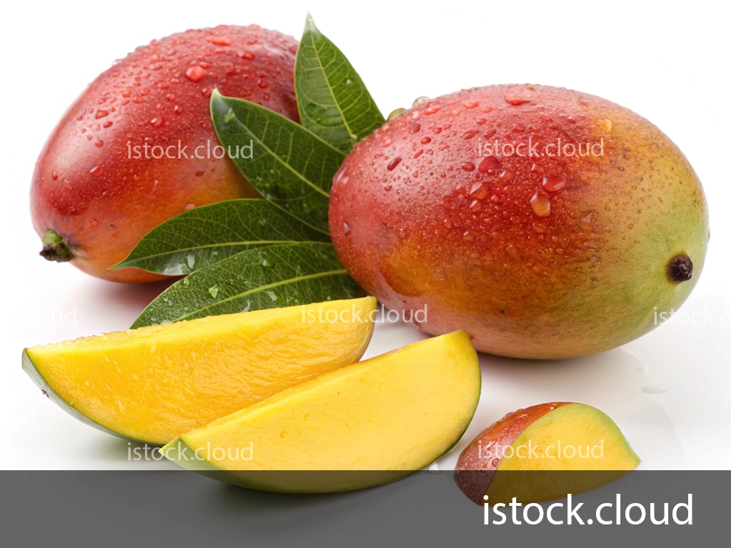 Two ripe mangoes with droplets of water on their surface, accompanied by green leaves, and several yellow mango slices arranged beside them.