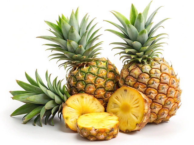 Three ripe pineapples with green foliage alongside one freshly cut pineapple slice, showcasing their juicy yellow interior.