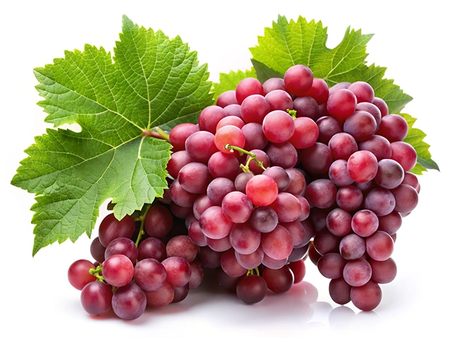 A bunch of fresh red grapes accompanied by green leaves, arranged on a white background.