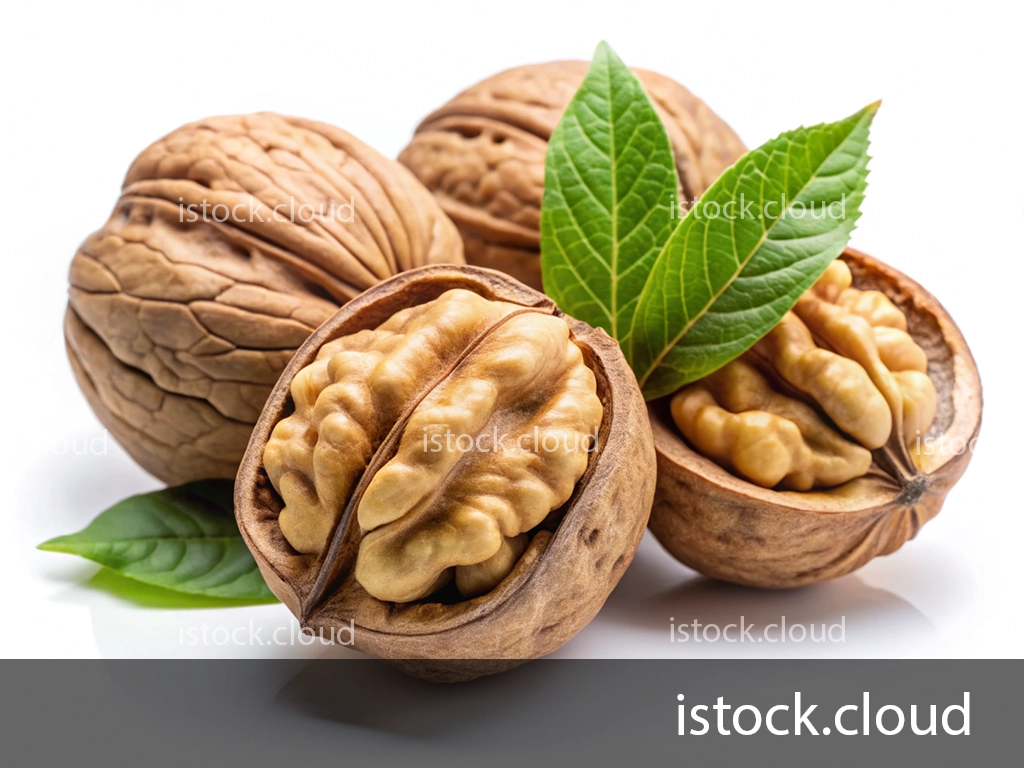 Two walnuts, one cracked open displaying the nut inside, accompanied by green walnut leaves on a white background.