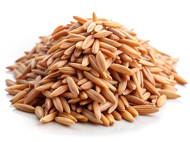 Close-up of a mound of paddy, featuring elongated, light brown texture, set against a white background.