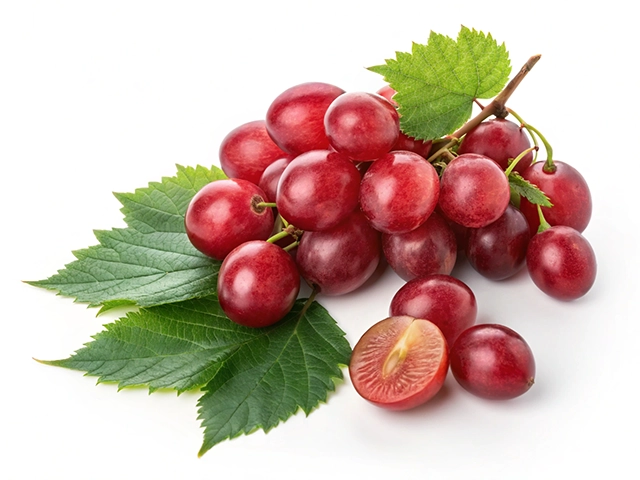 A cluster of fresh red grapes on green leaves, with one grape cut in half, revealing its juicy interior.